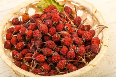 Kase ahşap arka plan üzerinde kuru alıç yığın