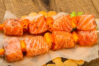 Pişmeye hazır baharatlı çiğ somon şişi.