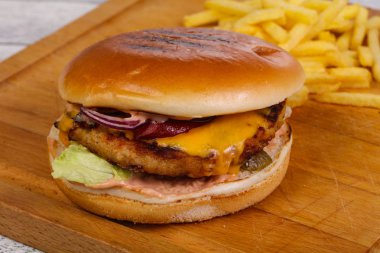 Tavuk, peynir, biber, salatalık ve kırmızı soğanlı hamburger.