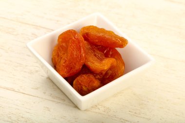 Kuru Kayısı yığın içinde kase ahşap arka plan üzerinde