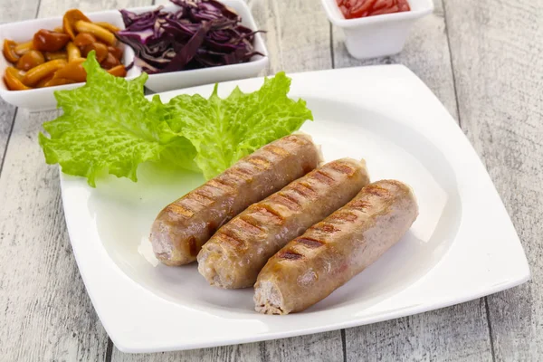 Grilled sausages served mushrooms and cabbage — Stock Photo, Image