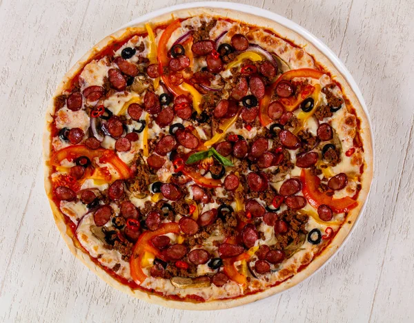 Pizza with sausages, cheese and minced meat