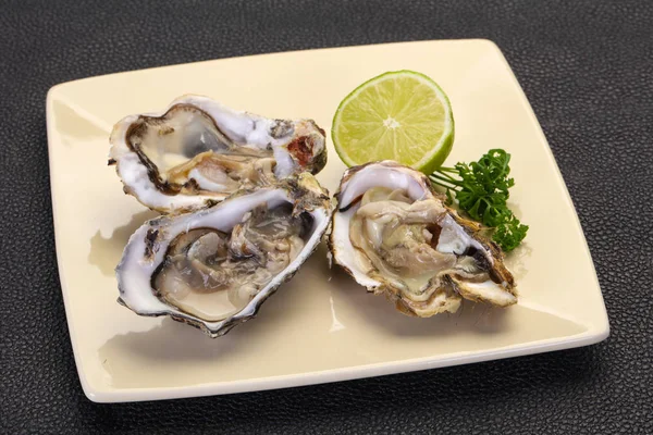 Oysters with lime and parsley — Stock Photo, Image