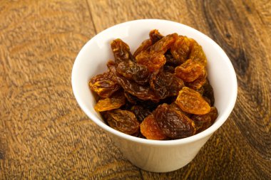 Ahşap arka plan üzerinde kase kuru kuru üzüm