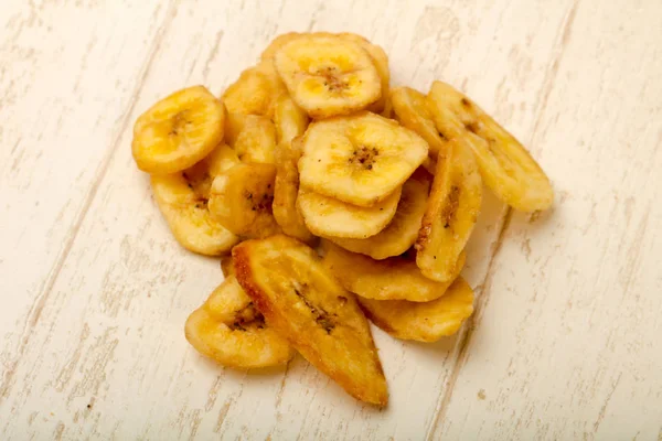 Dry banana chips on table