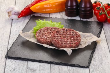 Çiğ burger pirzolası ızgara için hazır.