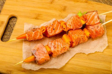 Pişmeye hazır baharatlı çiğ somon şişi.