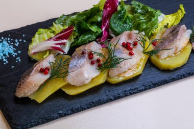 Patates ve soğanlı ringa balığı.