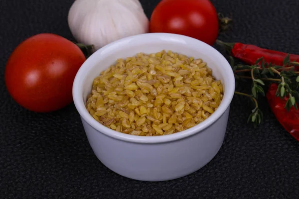 Bulgur crudo en el bowl con tomates y ajo — Foto de Stock