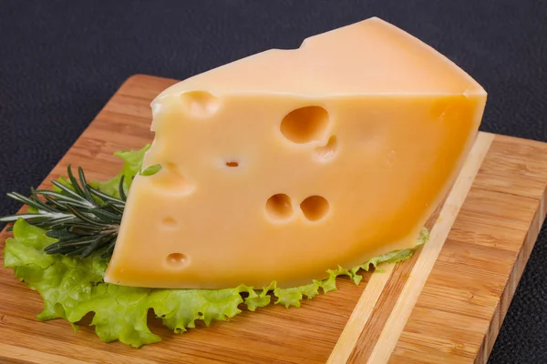 Maasdam-Käse im Brett serviert Salatblätter — Stockfoto