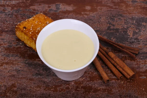 Condenced süt sinnamon ve hamur işi bir kase içinde — Stok fotoğraf