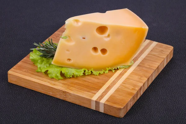 Maasdam kaas in de Raad van bestuur diende salade bladeren — Stockfoto