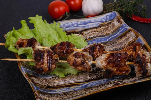 Espetos de carne de porco no prato com folhas de salada e tomates — Fotografia de Stock