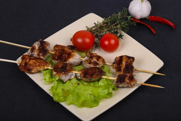 Brochettes de kebab de porc dans l'assiette avec feuilles de salade et tomates — Photo