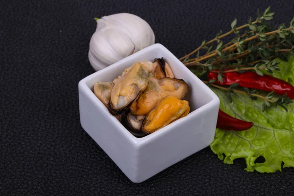 Маринованные мидии в миске служил перец, чеснок и салат — стоковое фото