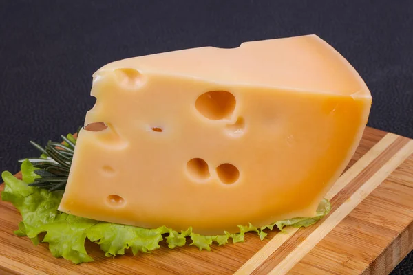 Maasdam-Käse im Brett serviert Salatblätter — Stockfoto