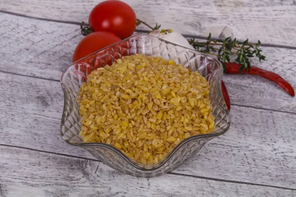 Bulgur crudo en el bowl con tomates y ajo — Foto de Stock