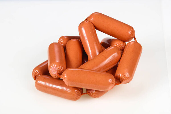 Вкусные мясные колбаски на белом фоне
