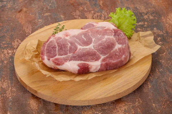 Ακατέργαστη μπριζόλα χοιρινού κρέατος πάνω από ξύλινη σανίδα — Φωτογραφία Αρχείου