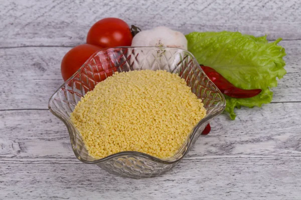 Råa couscous i skålen var sallad blad, tomat och paprika — Stockfoto