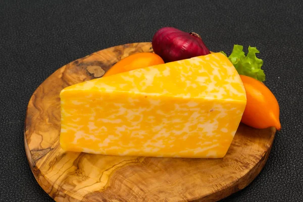 Triângulo de queijo de mármore sobre madeira — Fotografia de Stock
