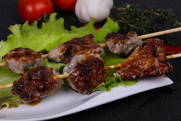 Espetos de carne de porco no prato com folhas de salada e tomates — Fotografia de Stock