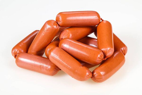 Вкусные мясные колбаски на белом фоне
