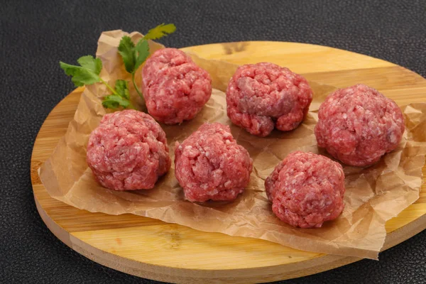 Raw meatball over wooden background — Stock Photo, Image