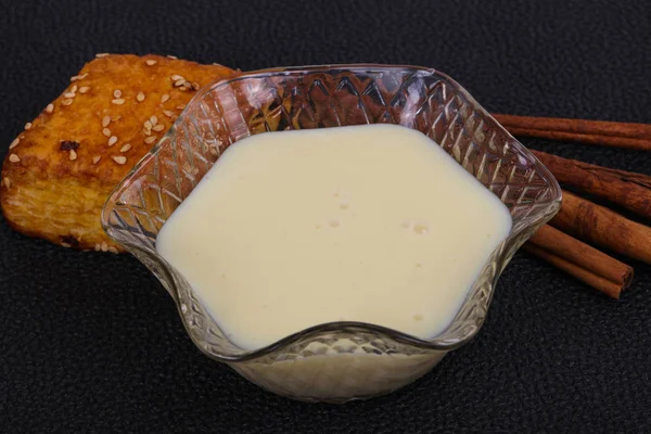 Condenced milk in the bowl with sinnamon and pastry — Stock Photo, Image