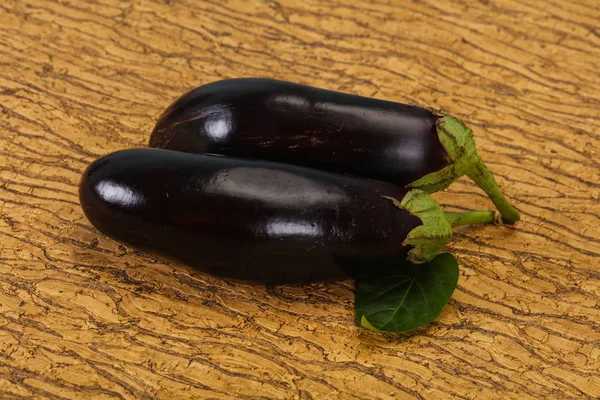 Reife, schmackhafte Auberginen vor hölzernem Hintergrund — Stockfoto