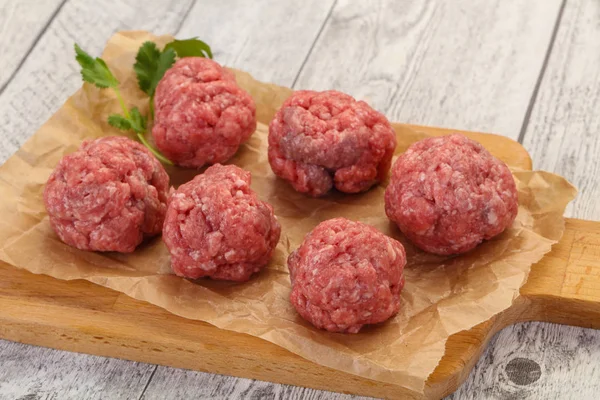 Raw meatball over wooden background — Stock Photo, Image