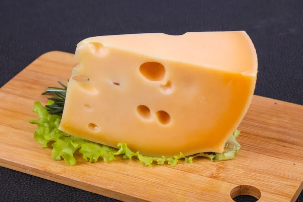Маасдамский сыр в доске подают листья салата — стоковое фото
