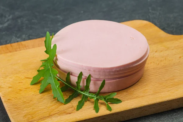 Sliced sausage over the wooden board — Stock Photo, Image