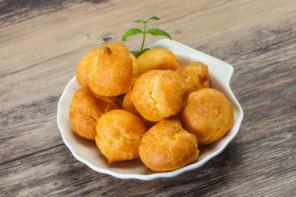 Dulces profiteroles sabrosos montón en el tazón — Foto de Stock