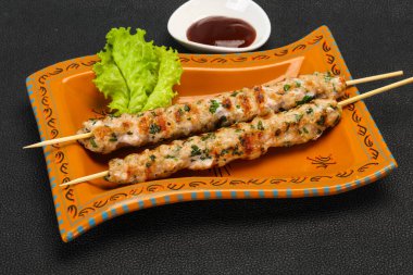 İnce kıymalı domuz şişi kebap ve bbq sosu.