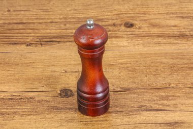 Wooden pepper mill for seasonong over background