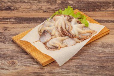 Çiğ deniz ürünleri - ahtapot tahtada pişirmek için.