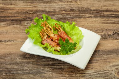 Kızarmış enoki mantarı ve domuz pastırması fesleğen yaprağı.