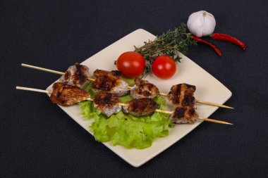 Salata yapraklı ve domatesli domuz kebabı kekik ve garkik servis edilir.