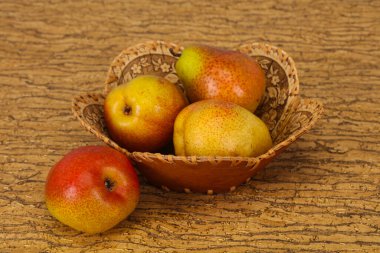 Tahta sepetteki olgun armut yığını.