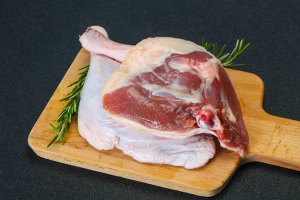 Raw duck leg served rosemary for cooking