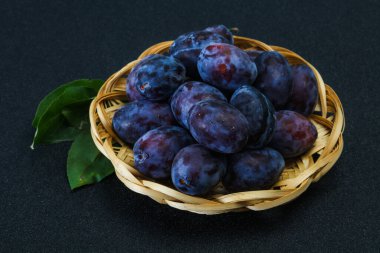 Olgun erik yığını sepetin içinde yapraklarla