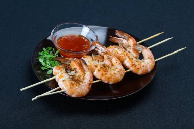 Baharatlı soslu ızgara karides şişi.