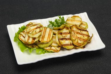 Izgara patlıcan dilimleri fesleğen ve salata yaprakları servis edilir.