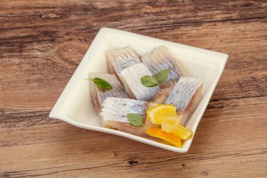 Dilimlenmiş limonla marine edilmiş ringa filetosu.