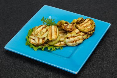 Izgara patlıcan dilimleri fesleğen ve salata yaprakları servis edilir.