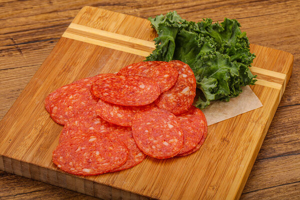 Italian spycy pepperoni sausage slices over board