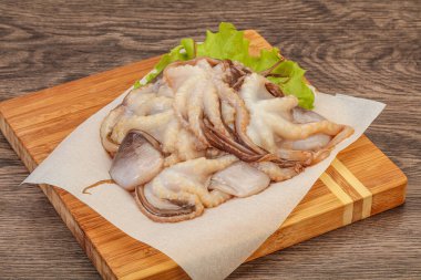 Çiğ deniz ürünleri - ahtapot tahtada pişirmek için.