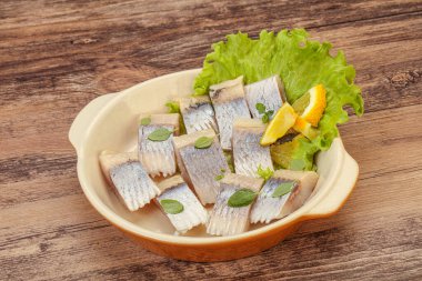 Dilimlenmiş limonla marine edilmiş ringa filetosu.