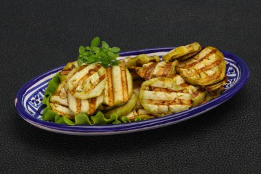 Izgara patlıcan dilimleri fesleğen ve salata yaprakları servis edilir.